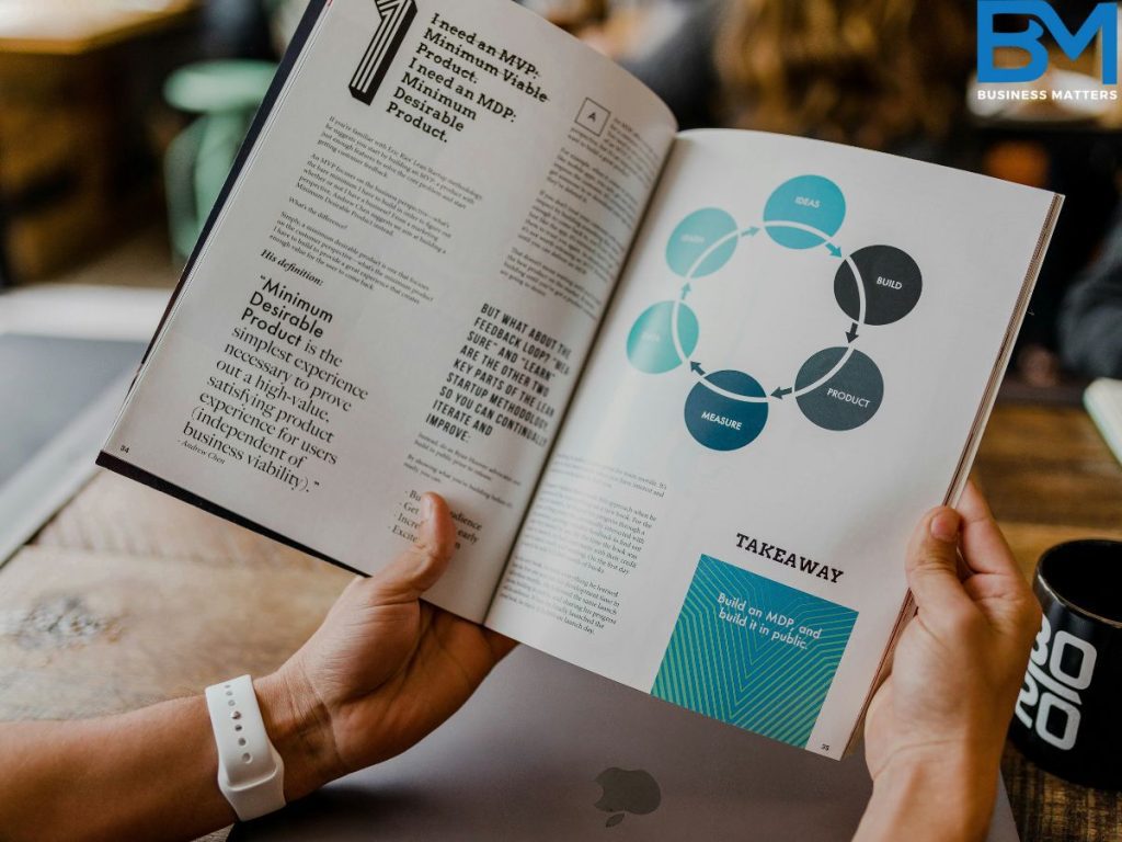 an individual reading a business magazine alond with a coffee on a coffee table