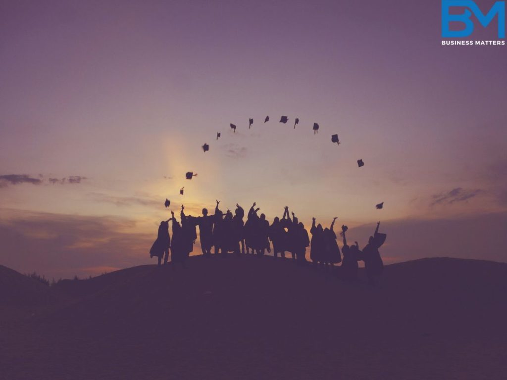 A group of kids throwing up their graduation caps showing the group learning and future of Learning