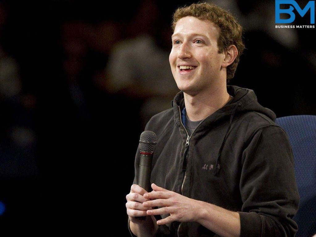 Meta Youngest CEO Mark Zuckerberg, holding a mic in his hand and smiling. 