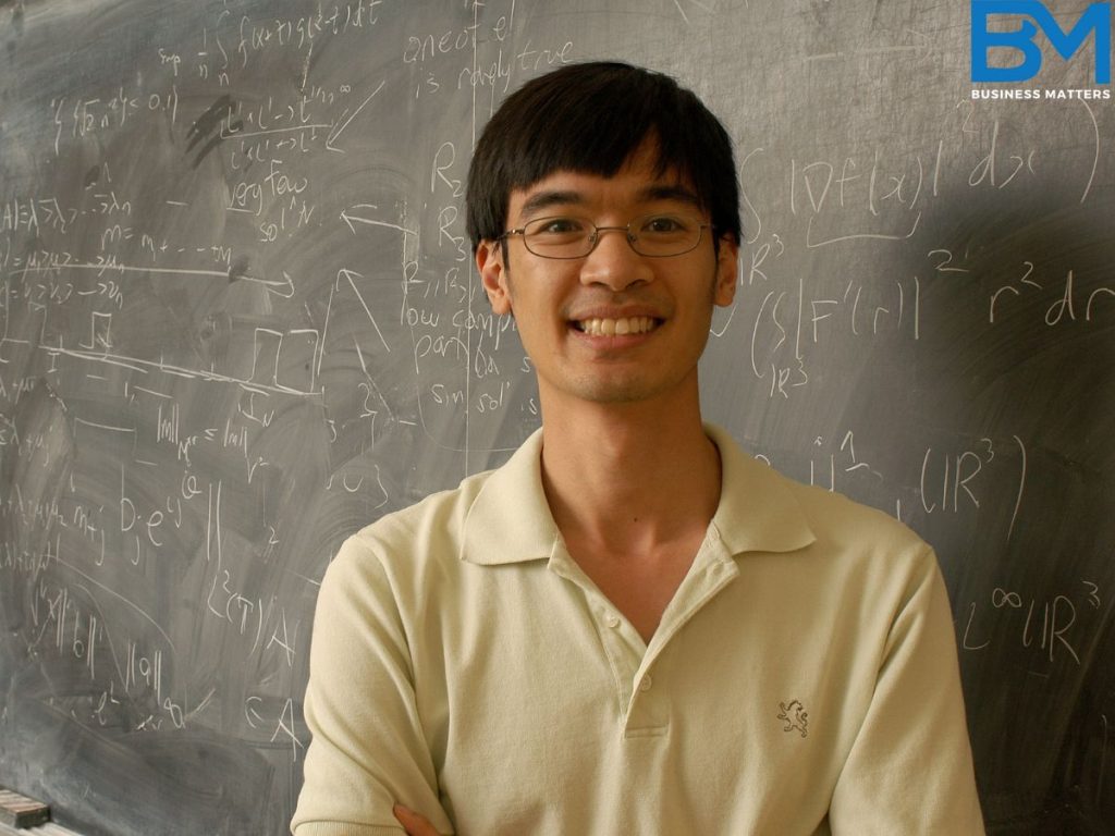 Terence Tao, highest IQ person in the world, standing in a classroom